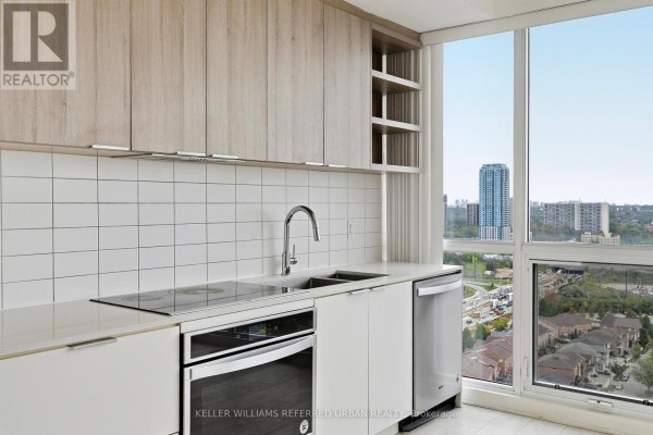Close-up of the kitchen sink, induction stovetop, and white subway tile backsplash. - 2207 - 6 Sonic Way, Toronto