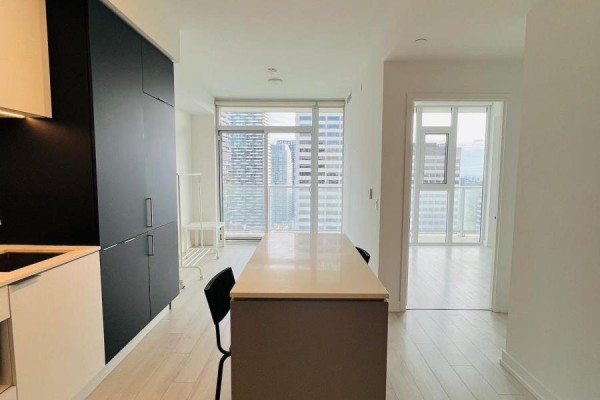 Open-concept kitchen and dining area with a large island and city view through floor-to-ceiling windows. - 2208 - 33 Helendale Avenue, Toronto