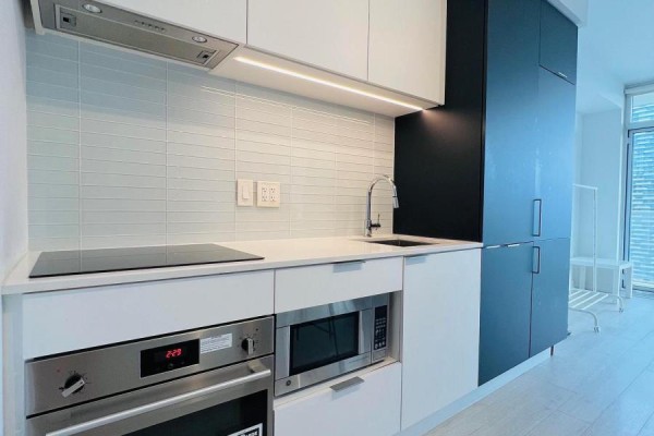 Modern kitchen with stainless steel appliances, white cabinetry, and a subway tile backsplash. - 2208 - 33 Helendale Avenue, Toronto