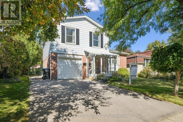 Front exterior of a two-story house with a driveway and mature trees on a sunny day. - 2209 Buttonbush Crescent, Mississauga