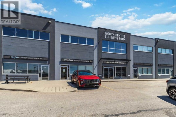 Close-up exterior view of the commercial building, highlighting various business entrances and windows. - 221, 2770 3 Avenue Ne, Calgary