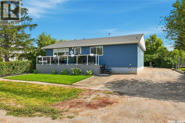 Side view of blue house with gravel driveway and green trees on a sunny day. - 221 Francis Street, Sedley