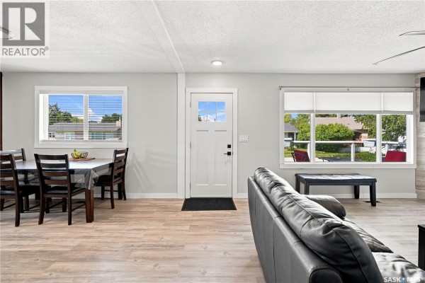 Interior view of a dining area and living room with a white front door and light wood flooring. - 221 Francis Street, Sedley