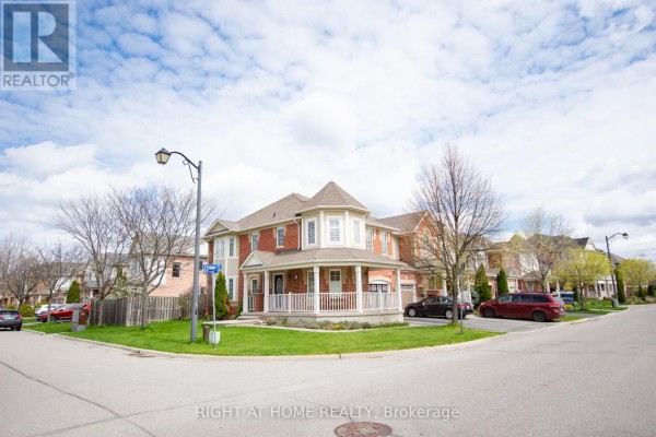 Street view of a brick townhouse complex with a paved road and sidewalks. - 221 Prosser Circle, Milton