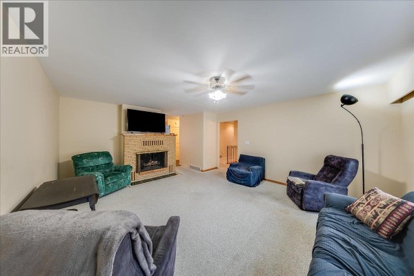 Living room with a brick fireplace, television, seating, and a ceiling fan with light. - 221 Second Avenue, Rivervale