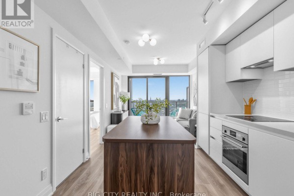 View from kitchen island showing open concept living space, balcony, and city skyline. - 2211 - 25 Frederick Todd Way, Toronto