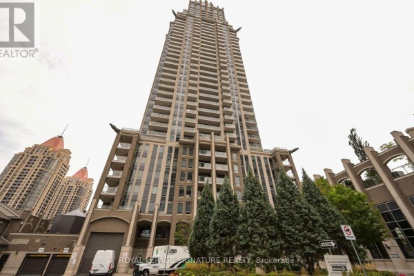 Low-angle view of the facade of a tall apartment building with balconies and architectural details. - 2211 - 388 Prince Of Wales Drive, Mississauga
