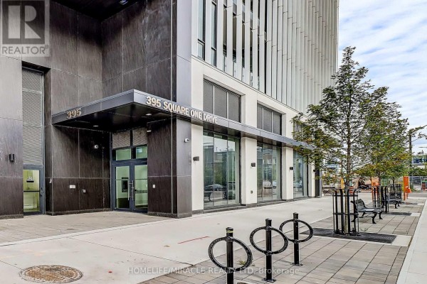 Entrance to 395 Square One Drive building with glass doors, signage, and bicycle racks. - 2211 - 395 Square One Drive, Mississauga