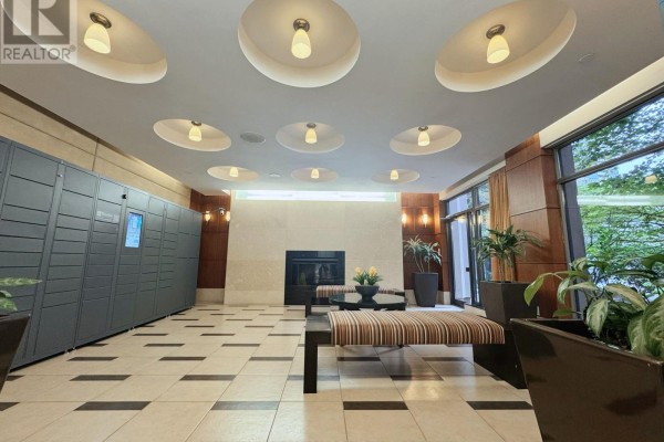 Lobby lounge with a fireplace, striped benches, planters, and a wall of gray package lockers. - 2213 - 10 Northtown Way, Toronto