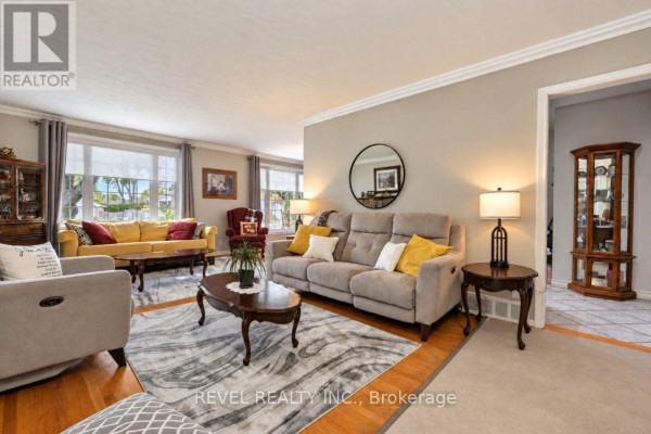 Living room with multiple sofas, accent chairs, coffee tables, and a large mirror on the wall. - 2213 Circle Place, Ottawa