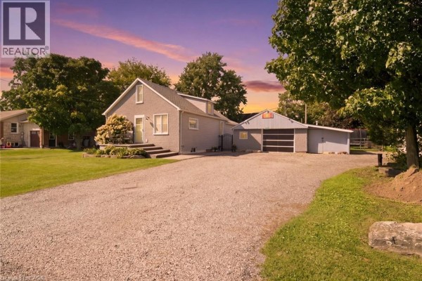 Grey house and detached garage exterior with a vibrant sunset sky. - 2214 William Shakespeare Street, Shakespeare