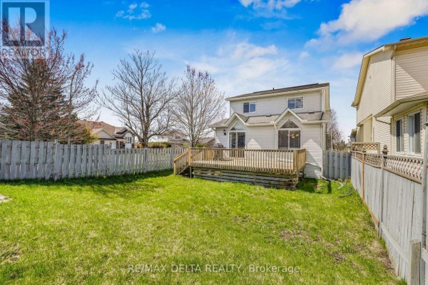 View of a wooden deck and backyard from the rear of the house, surrounded by a fence. - 2218 Cecile Crescent, Clarence Rockland