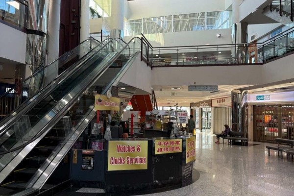 Interior mall view with escalators, shops, and a watches and clocks service kiosk. - 221a - 550 Hwy 7 E, Richmond Hill