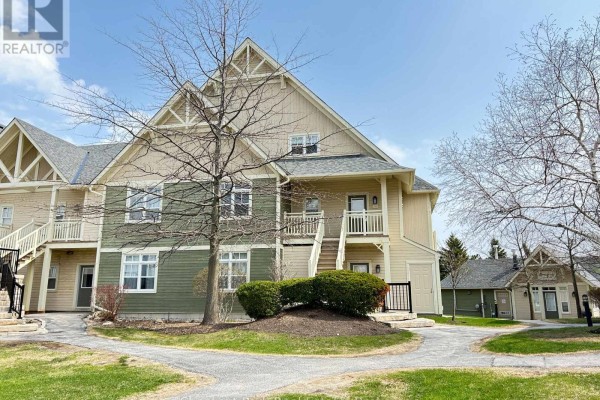 Townhouse exterior with beige and green siding, white trim, and pathways. - 222 - 125 Fairway Court, Blue Mountains