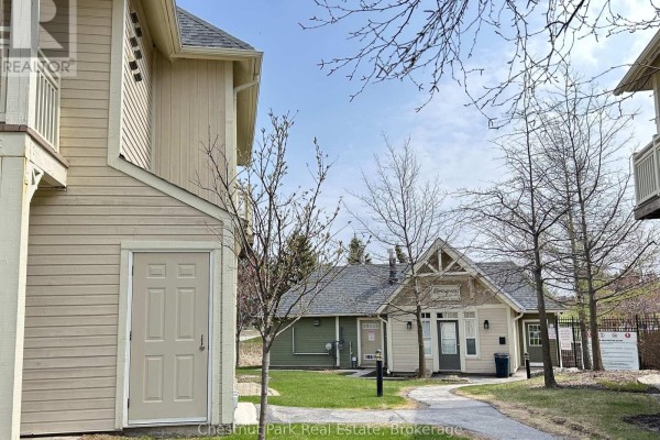 Townhouse exterior with beige siding and a small attached storage unit. - 222 - 125 Fairway Court, Blue Mountains