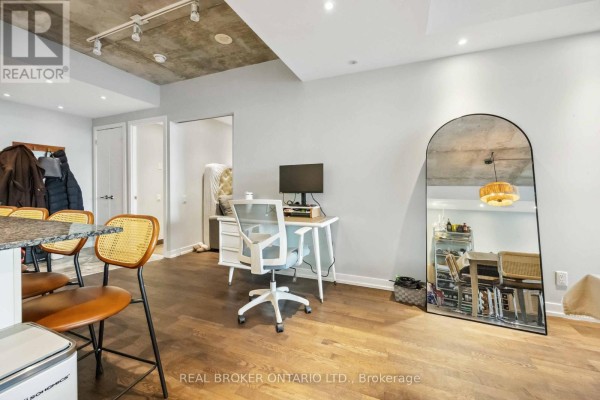 Living space with a desk, computer, office chair, and a large arched mirror. - 222 - 95 Bathurst Street, Toronto