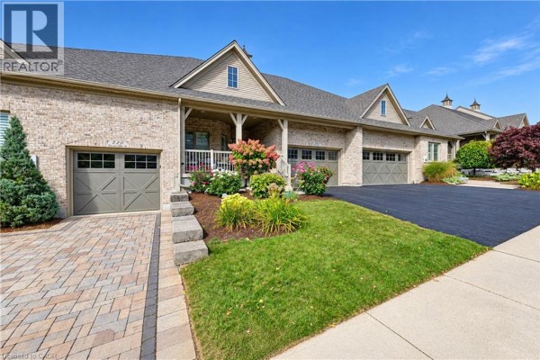 Right side exterior view of brick townhouse with paved driveway and walkway. - 222 Chestnut Hill Crescent, Kitchener