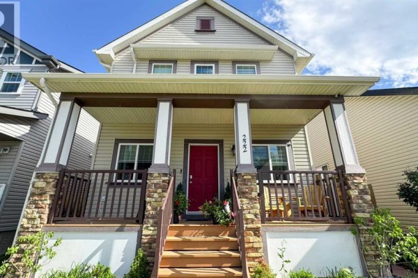 Close-up of the covered front porch with stone accents and a red front door. - 222 Copperpond Boulevard Se, Calgary