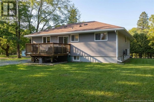 Side and rear exterior view of the gray bungalow showing siding and green lawn. - 222 Gondola Point Road, Rothesay