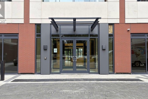Well-equipped apartment building gym with treadmills, ellipticals, and weight machines next to large windows. - 2220 - 4010 Eglinton Avenue W, Toronto