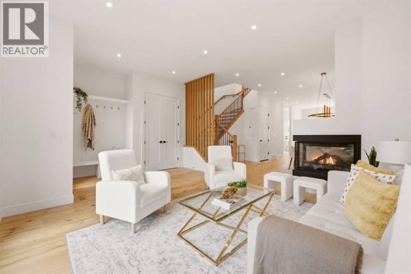 Staircase with wooden railing and open layout leading to upper level - 2229 36 Street Sw, Calgary