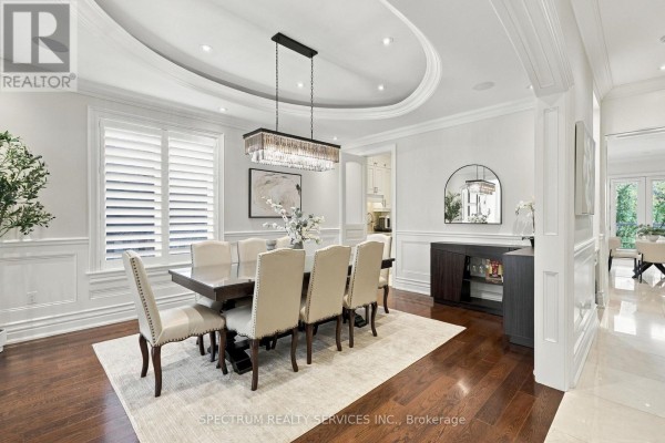 Dining room with a long table, upholstered chairs, and a chandelier, adjacent to the sitting area - 223 Lennox Avenue, Richmond Hill