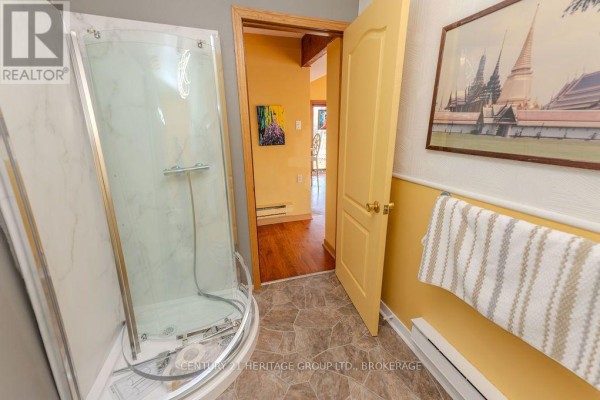 Glass shower stall and hallway with yellow walls - 2238 Little Long Lake Road Frontenac