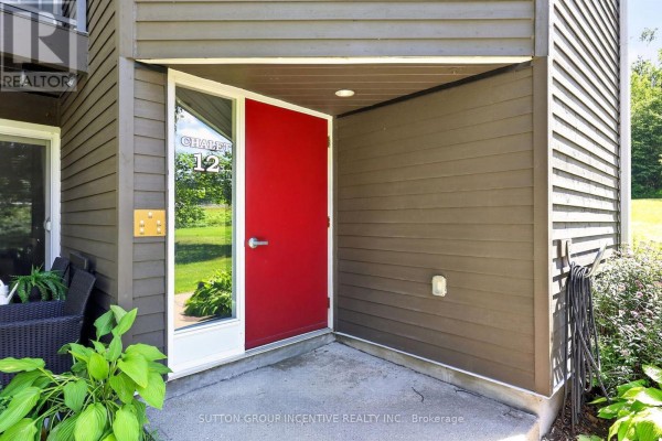 Close-up of a red apartment entrance door numbered 12 with glass accents. - 224 - 1102 Horseshoe Valley Road W, Oro Medonte
