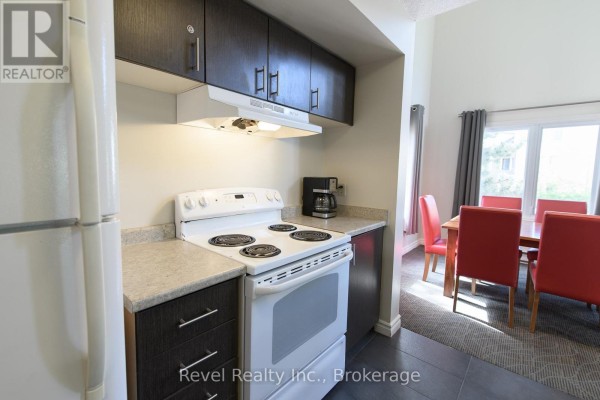 Kitchen with dark wood cabinets, white stove, refrigerator, and coffee maker. - 224 - 169 Jozo Weider Boulevard, Blue Mountains