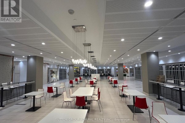 Food court area in a mall with tables, chairs, and open storefronts. - 224 - 7777 Weston Road, Vaughan