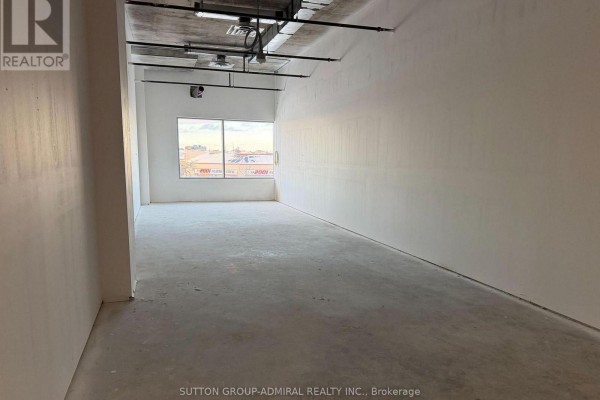 Empty commercial space with concrete floors, white walls, and a large window. - 224 - 7777 Weston Road, Vaughan