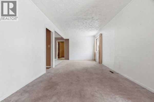 Spacious living room with carpet, natural light, and open layout. - 224 1 Street S, Vulcan