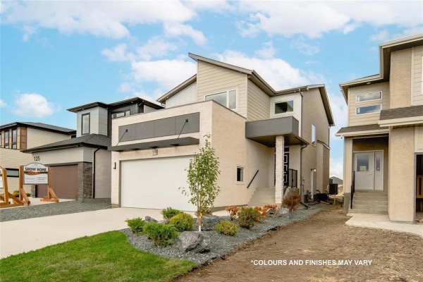 Side exterior view of a modern two-story house with a concrete driveway and landscaping. - 224 Blossom Way, West St Paul