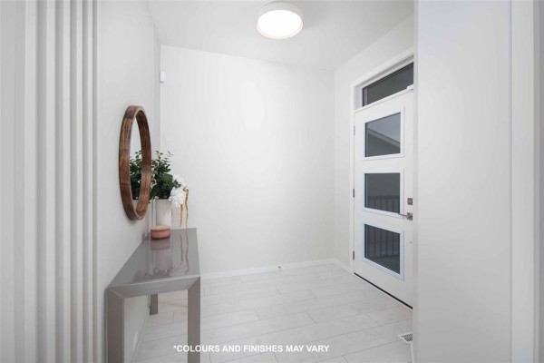 Bright entryway with white walls, white tiled floor, a console table, and a glass door. - 224 Blossom Way, West St Paul