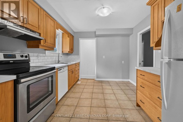 Kitchen with oak cabinets, stainless steel stove, dishwasher, and white subway tile backsplash. - 224 Culver Crescent, London East