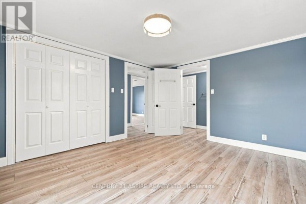 Hallway with blue walls, modern light, and wood-look flooring - 224 Nelson Street Pembroke