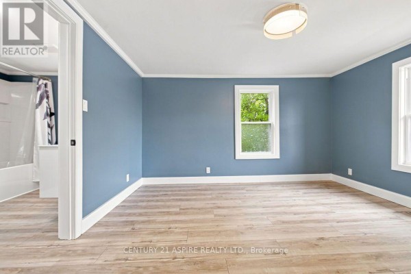 Bedroom with blue walls, wood-look floors, and window - 224 Nelson Street Pembroke