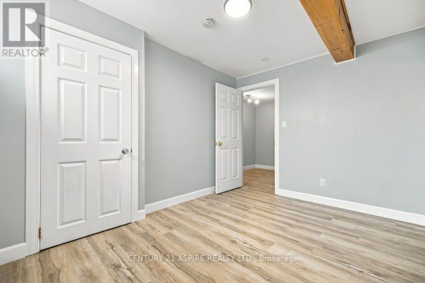 Hallway with wood-look floors, white doors, and exposed beam - 224 Nelson Street Pembroke