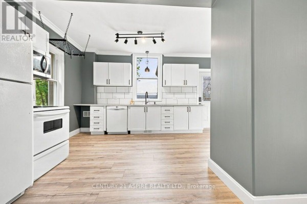 Renovated kitchen with white cabinets, appliances, subway tile backsplash, and wood-look floors - 224 Nelson Street Pembroke