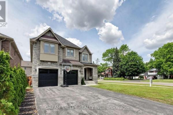View of a large stone and brick house from the driveway with a basketball hoop. - 224 Severn Street, Oshawa