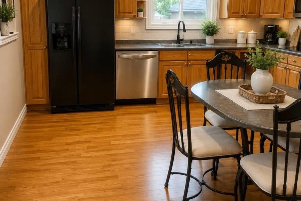 Kitchen view showing a black refrigerator, stainless steel dishwasher, and a dark oval table. - 2241 Four Mile Creek Road, Niagara On The Lake