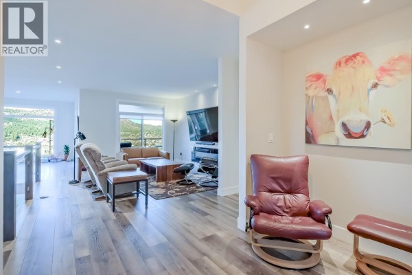 Open concept living room and dining area with large windows and mountain views. - 2241 Rojem Road, Kelowna