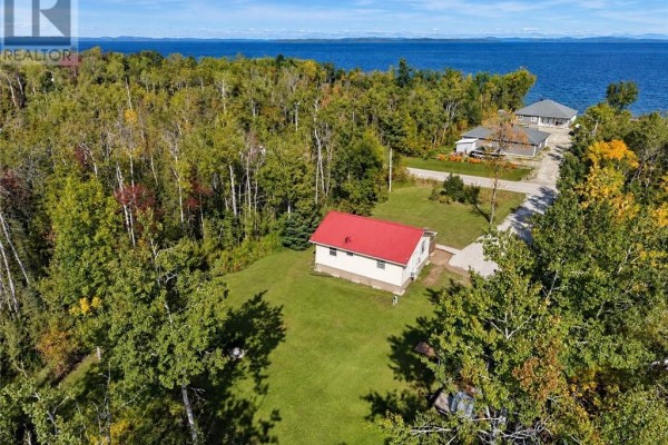Aerial view of the cottage and surrounding property showing proximity to a large body of water and neighboring houses. - 2247 Bay Estates, Nemi