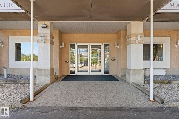 Exterior view of glass double doors leading into the apartment building lobby. - #225 10511 42 Av Nw, Edmonton