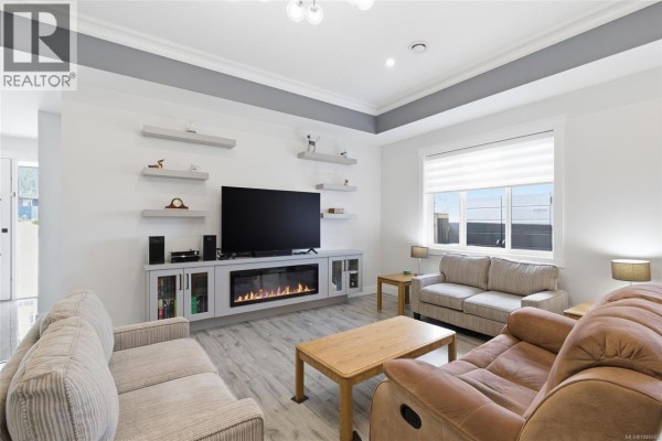 Living room with two sofas, a recliner, wooden coffee table, and electric fireplace. - 225 Dunbar Way, Parksville