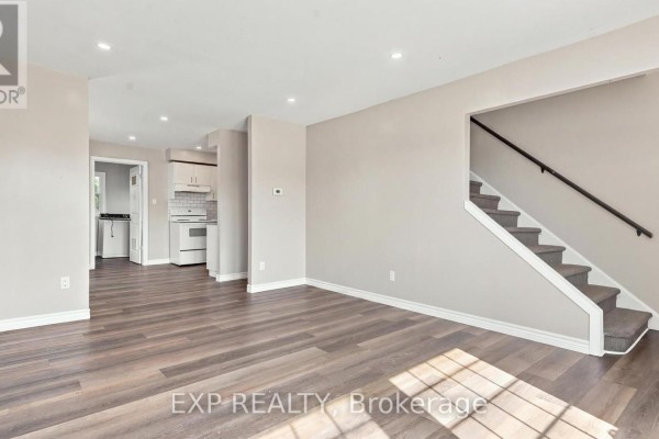 Interior living room with dark wood floors, gray walls, and a staircase leading upstairs. - 225 Grantham Avenue, St  Catharines