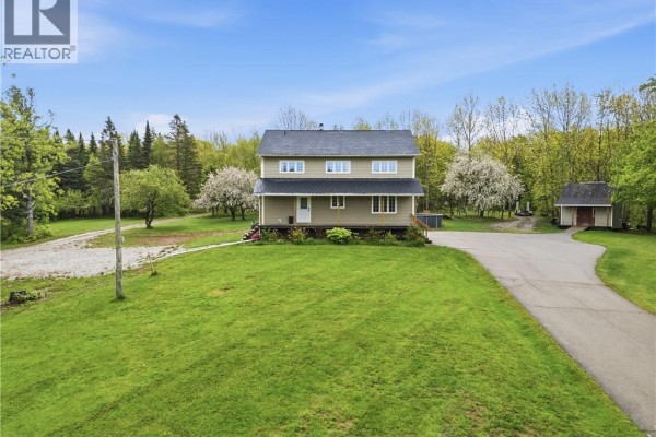 Kitchen with wood cabinets, stainless steel appliances, and island with bar stools. - 225 Quirk Road, Wards Creek
