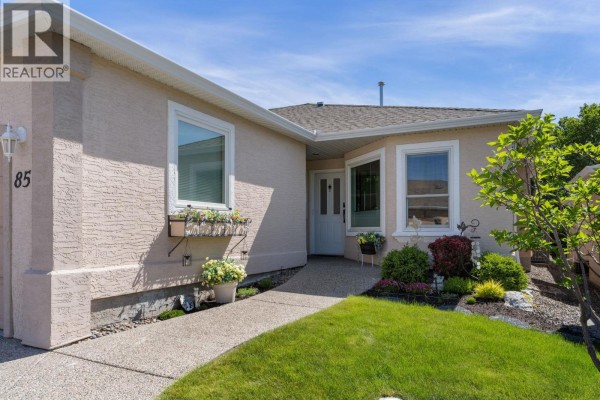 Close-up exterior view of the duplex entrance with windows and flower boxes. - 2250 Louie Drive Unit# 85, Westbank