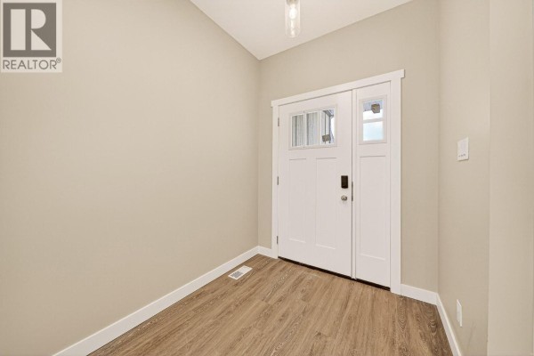 Unfinished basement rec room with beige walls, grey carpet, recessed lighting, and a carpeted staircase. - 2252 Black Hawk Drive, Sparwood