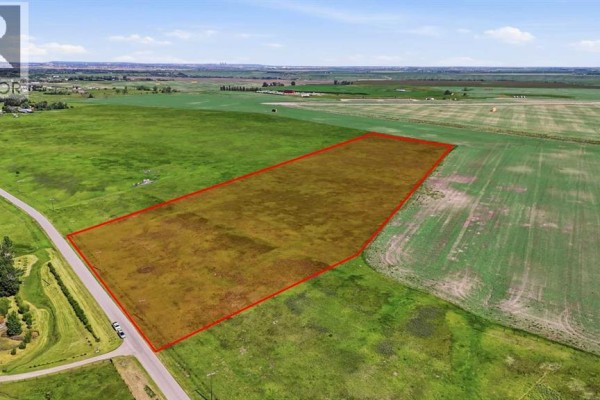 Aerial view of the property lot, marked in red, located at the corner of a paved road and a gravel road. - 2253 Drive, Rural Foothills County